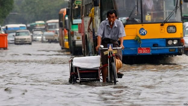 Người dân Myanmar di chuyển trên một con đường ngập nước do lũ lụt   Ảnh:EPA