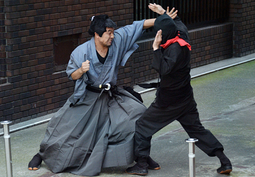 Members of a pantomime group wearing a samurai and a ninja costume performing in Tokyo  Photo: AFP