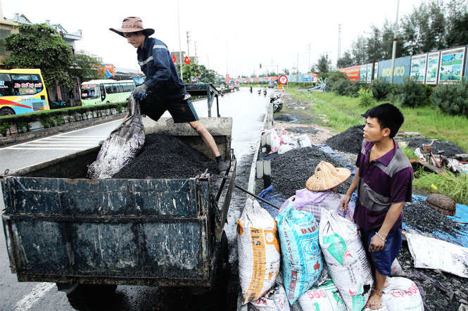 Than sau khi được đưa lên bờ sẽ được đóng gói và di chuyển lên xe để chuyển về các kho tập kết - Ảnh: Nguyễn Khánh
